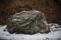 Giant stone in the snow. Natural background with a stone.