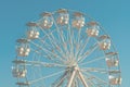 Giant white observation ferris wheel for panoramic view in amusement park is popular entertaining ride, shot against blue sky on Royalty Free Stock Photo