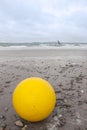 Giant yellow buoy on beach Royalty Free Stock Photo