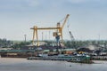 Giant yellow crane and coal hills along Long Tau River, Phuoc Khanh, Vietnam