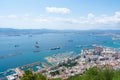 Gibraltar, Aerial view on buildings, city and coast of sea. Crystal clear blue water against mountains