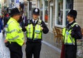 Three policemen in helmets talking in street