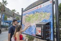 Young couple looking at large tourist map of Gibraltar.