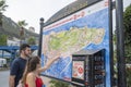 Young couple looking at large tourist map of Gibraltar.