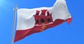 Gibraltarian flag waving at wind with blue sky, loop