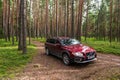 Gibuli parish, Latvia - July 31, 2022: Red Volvo XC70 car in a beautiful pine forest Royalty Free Stock Photo