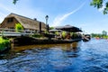 GIETHOORN, NETHERLANDS - JULY 17,2016: Tourists renting boats on the canal between houses in the famous village of Giethoorn, The