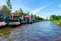 GIETHOORN, NETHERLANDS - JULY 17,2016: Tourists renting boats on the canal between houses in the famous village of Giethoorn, The