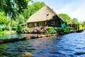 GIETHOORN, NETHERLANDS - JULY 17,2016: Tourists renting boats on the canal between houses in the famous village of Giethoorn, The