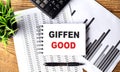 GIFFEN GOOD text on notebook on chart with calculator and pen Royalty Free Stock Photo