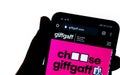 GiffGaff website on the smartphone hold by a silhouette of a hand in front of white screen. No alterations and editing to the phot