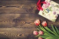 Gift bag and tulip flowers on a rustic table with space for text Royalty Free Stock Photo