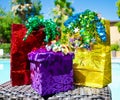 Gift bags and box with ribbon by the swimming pool