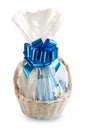 Gift basket, hamper packed in transparent paper with a big blue bow isolated on a white background Royalty Free Stock Photo