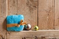 Gift in a beautiful package and tied with a ribbon and two Christmas balls on old wooden background wall. Royalty Free Stock Photo