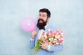 Gift bouquet. Present for spouse. Guy with air balloon. Birthday party. Bearded man hipster with flower bouquet. 8 march