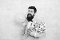 Gift bouquet. Present for spouse. Guy with air balloon. Birthday party. Bearded man hipster with flower bouquet. 8 march