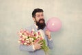 Gift bouquet. Present for spouse. Guy with air balloon. Birthday party. Bearded man hipster with flower bouquet. 8 march