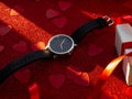 Gift box and black watch is on red heart paper background