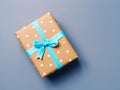 Gift box with blue ribbon on blue gray background, top view