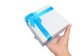 Gift box with blue ribbon and bow in hand white background Royalty Free Stock Photo