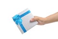 Gift box with blue ribbon and bow in hand white background Royalty Free Stock Photo