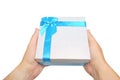 Gift box with blue ribbon and bow in hand white background Royalty Free Stock Photo