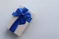 Gift box with blue ribbon on white table background. Fathers day present for dad. Top view, copy space Royalty Free Stock Photo
