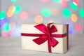 Gift box on a blurry background of holiday lights. Christmas lights, beautiful bokeh. Greeting card. The concept of the Royalty Free Stock Photo