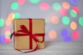 Gift box on a blurry background of holiday lights. Christmas lights, beautiful bokeh. Greeting card. The concept of the Royalty Free Stock Photo