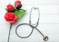 gift box, bouquet of red roses, stethoscope Red hearts, isolate on a wooden table white backdrop, Valentines Day concept. Royalty Free Stock Photo