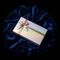 Gift Box with Bow on Blue Fabric Royalty Free Stock Photo