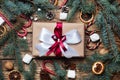 Gift box with bow. Christmas tree and decorations, cane caramel and oranges nuts Wooden background