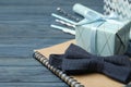 Gift box, bow and notebook on blue wooden table. Greeting card Royalty Free Stock Photo