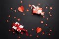 Gift box with bows and red paper hearts on black background Royalty Free Stock Photo
