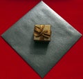 Gift box in bronze color with a bow and a black craft envelope on a red background Royalty Free Stock Photo