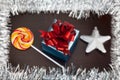 Gift box, candycane and white christmas star on black wood