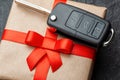 Gift box with car keys with remote control alarm system with red ribbon bow. Royalty Free Stock Photo
