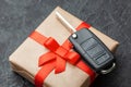 Gift box with car keys with remote control alarm system with red ribbon bow. Royalty Free Stock Photo