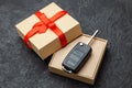 Gift box with car keys with remote control alarm system with red ribbon bow. Royalty Free Stock Photo