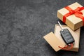 Gift box with car keys with remote control alarm system with red ribbon bow and label. Copy space for text. Royalty Free Stock Photo