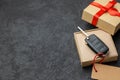 Gift box with car keys with remote control alarm system with red ribbon bow and label. Copy space for text. Royalty Free Stock Photo