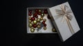 Gift box with Christmas globes inside against dark background