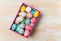 Gift box with colorful brighrt Easter eggs. Wooden background