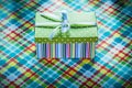 Gift box on colorful checked tablecloth holidays concept