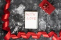 Gift box with curly red ribbon and notebook on old wall texture cement dark black gray background, concept of Valentines Royalty Free Stock Photo