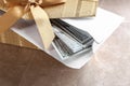 Gift box with dollar bills on brown table Royalty Free Stock Photo