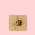 Gift box with dry orange and tied with twine on a pink pastel background