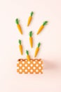 Gift box with Easter carrots on bright background. Minimal spring holiday concept