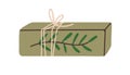 Gift box in eco paper wrapping with twine and green leaf branch. Holiday present decorated with leaves. Modern package